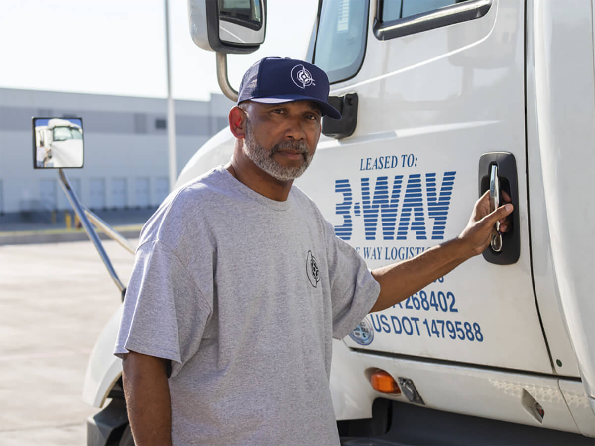 from-port-to-production A Three Way Logistics truck driver opening a truck door
