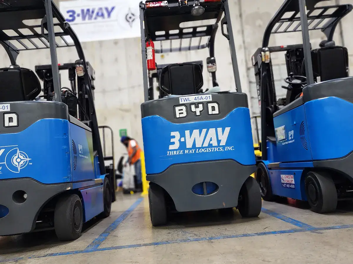 Three-Forkslifts-warehouse Three blue forklifts