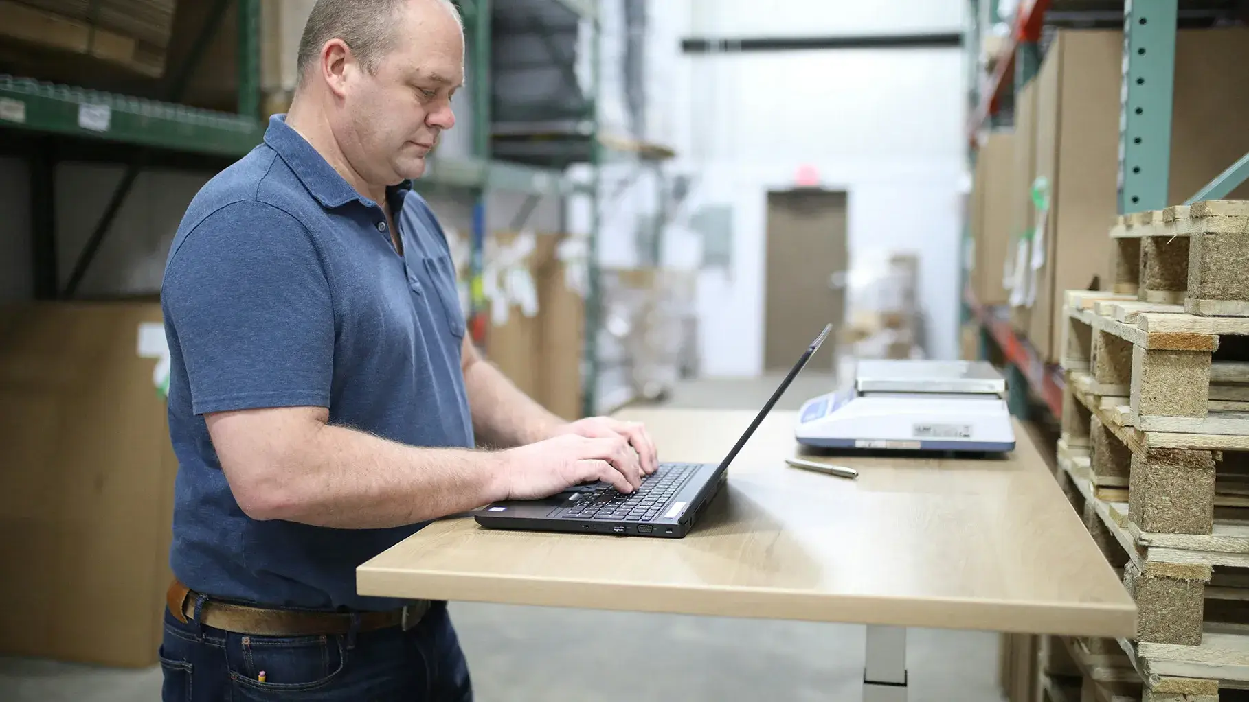 A warehouse employee working on a laptop