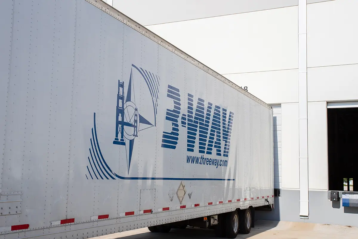 Why Exhibit at a Trade Show? - 3-WAY Three Way Logistics semi-trailer backed into a warehouse loading dock for freight transport