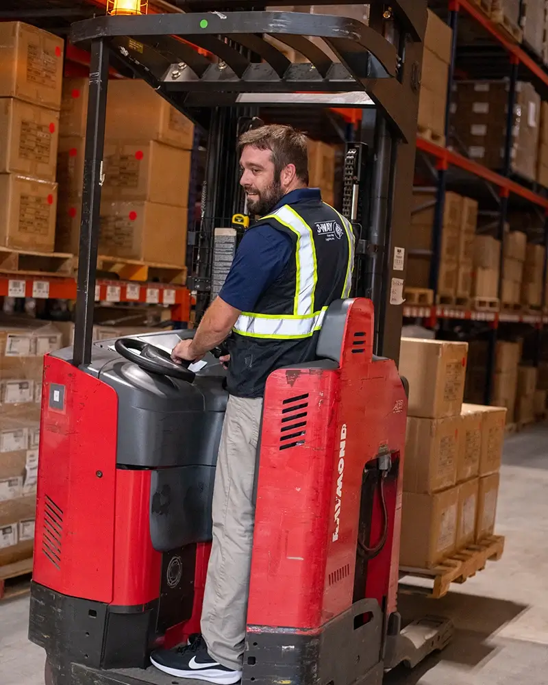 A warehouse worker on a forklift